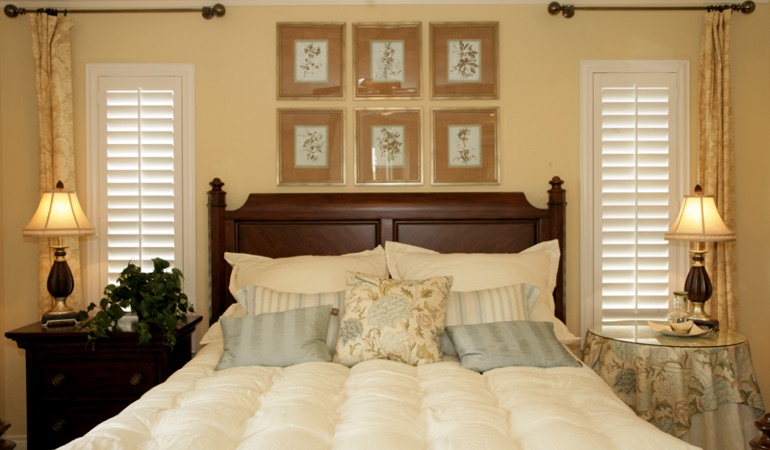 Bedroom with two tall plantation shutters on either side of bed in Cleveland 